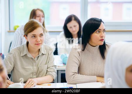 Studenti multietnici seduti alla scrivania insieme in classe Foto Stock