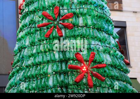 Bordeaux, Francia. 23 dicembre 2023. Ecologia e albero di Natale 100% eco-responsabile. Questo albero di Natale creato con 3000 bottiglie di plastica recuperate aumenta la consapevolezza del consumo eccessivo di plastica che inquina gli oceani e il pianeta. I visitatori sono incoraggiati ad adottare comportamenti più ecologici nella loro vita quotidiana per ridurre o evitare questo inquinamento. Ogni minuto quasi un milione di bottiglie di plastica vengono vendute in tutto il mondo. Foto di Hugo Martin/Alamy Live News. Foto Stock