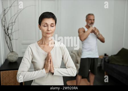Coppia che fa esercizi di yoga a casa la mattina Foto Stock