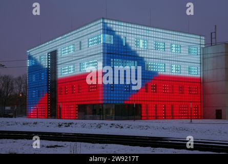 Ostrava, Repubblica Ceca. 23 dicembre 2023. L'edificio della Facoltà di Belle Arti e musica dell'Università di Ostrava illuminato con la bandiera ceca per commemorare le vittime della sparatoria del 21 dicembre presso la Facoltà di Arti dell'Università Carlo di Praga, il giorno del lutto di Stato, 23 dicembre 2023, a Ostrava, Repubblica Ceca. Crediti: Petr Sznapka/CTK Photo/Alamy Live News Foto Stock