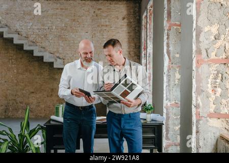 Architetti che discutono su campioni di piastrelle in ufficio Foto Stock