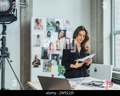 Rivista influencer Reading in studio Foto Stock