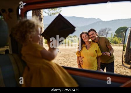 La ragazza mostra la cornice della loro famiglia ai suoi genitori Foto Stock