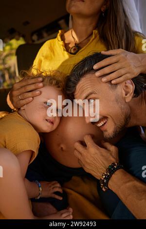 Ragazza e uomo che ascoltano la pancia di una donna incinta Foto Stock