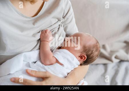 Madre che allatta il bambino in braccio Foto Stock