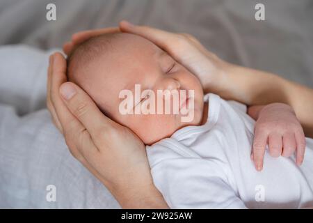 Neonato bambino che dorme nelle mani di madre Foto Stock