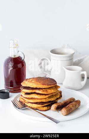 Una pila di pancake di patate dolci serviti con salsicce per colazione. Foto Stock