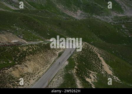 Due ciclisti fanno un giro in bicicletta lungo una tortuosa strada di montagna Foto Stock