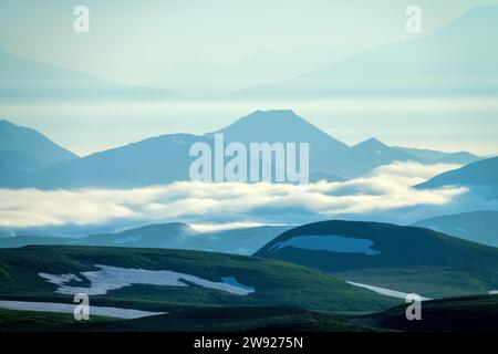 Le nuvole si gettano nella valle. Panorama di montagne vulcanogene Foto Stock