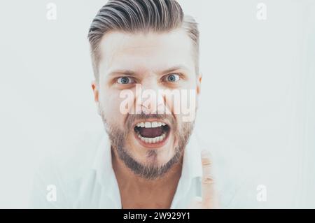 L'uomo elegante dal look pazzo guarda la fotocamera. Il concetto di soppressione, stimolazione, motivazione per il successo aziendale. Supporti misti Foto Stock
