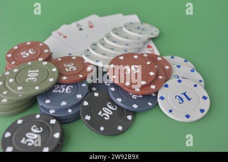 Pile di chip da poker e fan delle carte da gioco su un tavolo da gioco verde feltro, carte da poker e patatine Foto Stock
