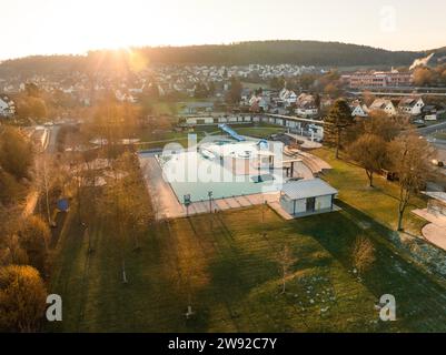 Alba sopra una piscina, catturata da una vista a volo d'uccello con nebbia intorno alle case, piscina all'aperto Calw, Stammheim di Stadtwerke Calw Foto Stock