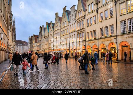 Münster, NRW, Germania. 23 dicembre 2023. Gli amanti dello shopping e i turisti di Natale passeggeranno lungo la graziosa strada medievale Prinzipalmarkt nella storica città gotica di Münster in un ultimo giorno di shopping piovoso prima della vigilia di Natale. Crediti: Imageplotter/Alamy Live News Foto Stock