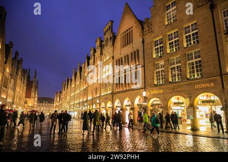 Münster, NRW, Germania. 23 dicembre 2023. Gli amanti dello shopping e i turisti di Natale passeggeranno lungo la graziosa strada medievale Prinzipalmarkt nella storica città gotica di Münster in un ultimo giorno di shopping piovoso prima della vigilia di Natale. Crediti: Imageplotter/Alamy Live News Foto Stock