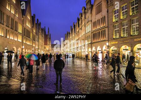 Münster, NRW, Germania. 23 dicembre 2023. Gli amanti dello shopping e i turisti di Natale passeggeranno lungo la graziosa strada medievale Prinzipalmarkt nella storica città gotica di Münster in un ultimo giorno di shopping piovoso prima della vigilia di Natale. Crediti: Imageplotter/Alamy Live News Foto Stock