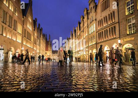 Münster, NRW, Germania. 23 dicembre 2023. Gli amanti dello shopping e i turisti di Natale passeggeranno lungo la graziosa strada medievale Prinzipalmarkt nella storica città gotica di Münster in un ultimo giorno di shopping piovoso prima della vigilia di Natale. Crediti: Imageplotter/Alamy Live News Foto Stock