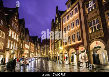 Münster, NRW, Germania. 23 dicembre 2023. Gli amanti dello shopping e i turisti di Natale passeggeranno lungo la graziosa strada medievale Prinzipalmarkt nella storica città gotica di Münster in un ultimo giorno di shopping piovoso prima della vigilia di Natale. Crediti: Imageplotter/Alamy Live News Foto Stock