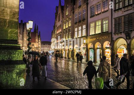 Münster, NRW, Germania. 23 dicembre 2023. Gli amanti dello shopping e i turisti di Natale passeggeranno lungo la graziosa strada medievale Prinzipalmarkt nella storica città gotica di Münster in un ultimo giorno di shopping piovoso prima della vigilia di Natale. Crediti: Imageplotter/Alamy Live News Foto Stock