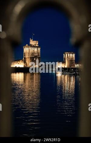 Ammira la balaustra del vecchio porto di la Rochelle di notte con le sue famose torri antiche. Foto Stock