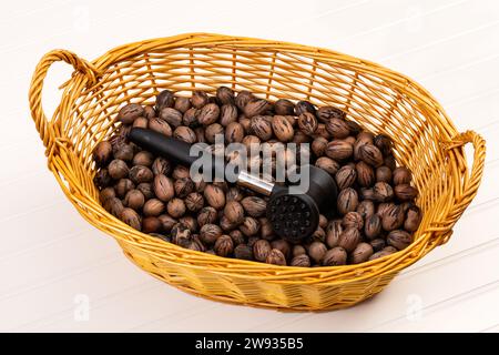 Dadi in Pecan in cestello di vimini con martello in gomma per la fessurazione, isolati su bianco. Foto Stock