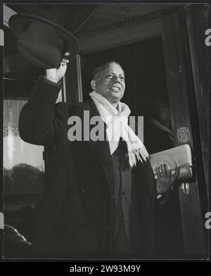 Uno dei partecipanti all'RTC: J.P. Kaulesar Sukul, 1948 fotografie documentarie uno dei partecipanti per conto del Suriname alla Tavola Rotonda Conferenza tra Paesi Bassi e Occidente: Il politico J.P. Kaulesar Sukul, presidente del partito indù Suriname e direttore facente funzione dell'Archivio centrale. Entra attraverso la porta girevole salutando con il suo cappello. L'Aia è un supporto fotografico per l'Aia. Paesi Bassi. Suriname Foto Stock