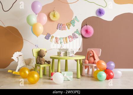 Interno per la festa di compleanno dei bambini con palloncini, giocattoli e mobili Foto Stock