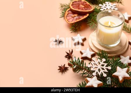 Biscotti al pan di zenzero a forma di stella con rami di abete e candela accesa su sfondo marrone Foto Stock