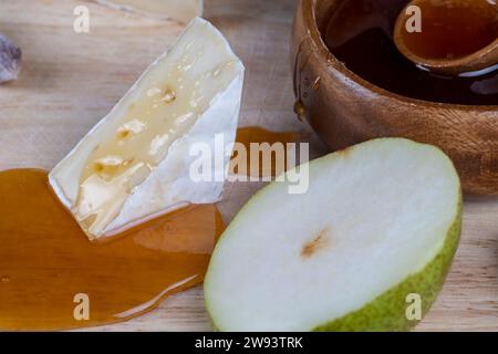 fette di pera verde sul tavolo durante la cottura, deliziosa e matura pera su un asse di legno Foto Stock