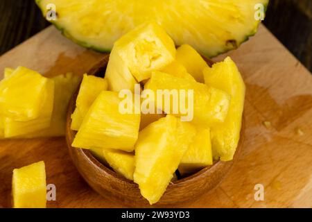 ananas giallo maturo a fette, un gran numero di pezzi di ananas maturo affettato a pezzi durante la cottura, primo piano Foto Stock