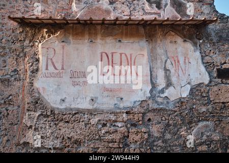 Napoli, Italia - 8 novembre 2023: Graffiti antichi latini su un muro di una delle rovine di Pompei Foto Stock