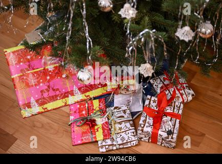 Berlino, Germania. 23 dicembre 2023. I regali avvolti giacciono sotto un albero di Natale. Crediti: Jens Kalaene/dpa/Alamy Live News Foto Stock