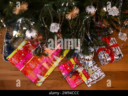 Berlino, Germania. 23 dicembre 2023. I regali avvolti giacciono sotto un albero di Natale. Crediti: Jens Kalaene/dpa/Alamy Live News Foto Stock