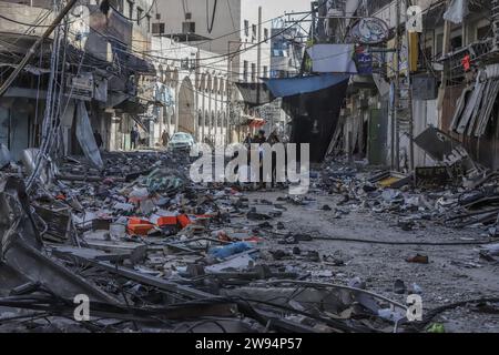 Khan Yunis, territori palestinesi. 24 dicembre 2023. I palestinesi ispezionano i danni dopo un attacco aereo israeliano al centro di Khan Yunis, a sud della Striscia di Gaza. Credito: Mohammad Abu Elsebah/dpa/Alamy Live News Foto Stock