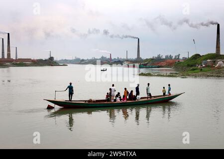 Sirajdikhan, Munshiganj, Bangladesh. 24 dicembre 2023. Il fumo viene emesso da un forno di mattoni sulla riva del fiume Dhaleshwari a Sirajdikhan upazila di Munshiganj. Questi fumi emessi per bruciare i mattoni contengono varie sostanze nocive, tra cui biossido di carbonio e monossido di carbonio, dannose per l'ambiente, le colture e le persone. Pertanto, il governo ha vietato la costruzione di forni in mattoni in città. (Immagine di credito: © Syed Mahabubul Kader/ZUMA Press Wire) SOLO USO EDITORIALE! Non per USO commerciale! Crediti: ZUMA Press, Inc./Alamy Live News Foto Stock