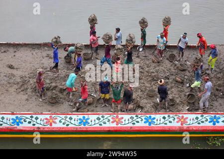 Sirajdikhan, Munshiganj, Bangladesh. 24 dicembre 2023. I lavoratori scaricano il terreno da una barca a Sirajdikhan nel Munisganj, che sarà utilizzata per fare mattoni in un forno. (Immagine di credito: © Syed Mahabubul Kader/ZUMA Press Wire) SOLO USO EDITORIALE! Non per USO commerciale! Crediti: ZUMA Press, Inc./Alamy Live News Foto Stock