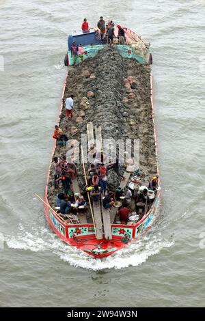 Sirajdikhan, Munshiganj, Bangladesh. 24 dicembre 2023. I lavoratori scaricano il terreno da una barca a Sirajdikhan nel Munisganj, che sarà utilizzata per fare mattoni in un forno. (Immagine di credito: © Syed Mahabubul Kader/ZUMA Press Wire) SOLO USO EDITORIALE! Non per USO commerciale! Crediti: ZUMA Press, Inc./Alamy Live News Foto Stock