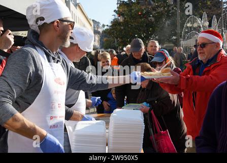 Pola, Croazia. 24 dicembre 2023. Persone che ricevono una porzione di un tradizionale risotto di pesce (risotto ai Fruitti di Mare) durante una tradizionale vigilia di Natale - materiale pubblicitario natalizio presso il mercato cittadino di Pola, Croazia, la vigilia di Natale del 24 dicembre 2023. Foto: SASA Miljevic/PIXSELL credito: Pixsell/Alamy Live News Foto Stock