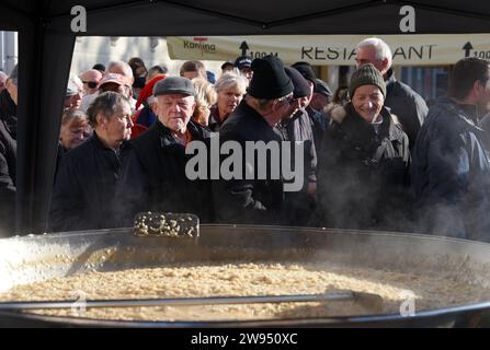 Pola, Croazia. 24 dicembre 2023. Persone che ricevono una porzione di un tradizionale risotto di pesce (risotto ai Fruitti di Mare) durante una tradizionale vigilia di Natale - materiale pubblicitario natalizio presso il mercato cittadino di Pola, Croazia, la vigilia di Natale del 24 dicembre 2023. Foto: SASA Miljevic/PIXSELL credito: Pixsell/Alamy Live News Foto Stock