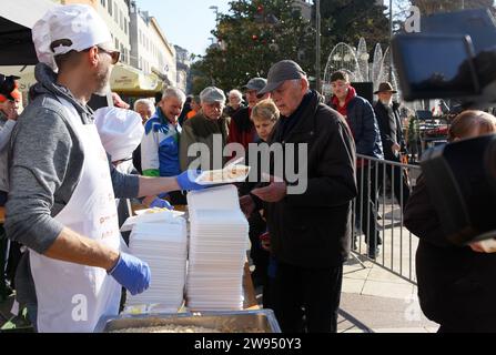 Pola, Croazia. 24 dicembre 2023. Persone che ricevono una porzione di un tradizionale risotto di pesce (risotto ai Fruitti di Mare) durante una tradizionale vigilia di Natale - materiale pubblicitario natalizio presso il mercato cittadino di Pola, Croazia, la vigilia di Natale del 24 dicembre 2023. Foto: SASA Miljevic/PIXSELL credito: Pixsell/Alamy Live News Foto Stock