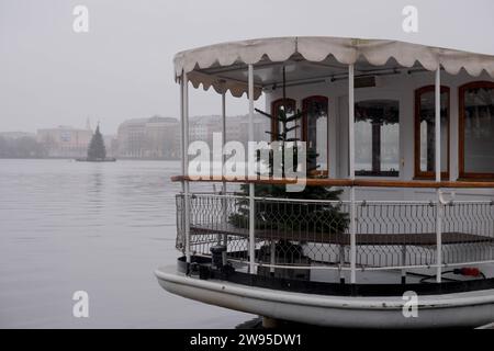 Amburgo, 24.12.2023 Tannenbaum auf dem Alsterdampfer St. Georg. Weihnachten fällt ins Wasser. Der Weihnachtsbaum am Heiligabend bei Dauerregen und grauem Himmel bei 11ÂC auf der Binnenalster. Amburgo Deutschland *** Amburgo, 24 12 2023 albero di Natale sul piroscafo Alster St Georg Christmas cade in acqua l'albero di Natale la vigilia di Natale sotto pioggia continua e cielo grigio alle 11C sul Binnenalster Amburgo Germania Foto Stock