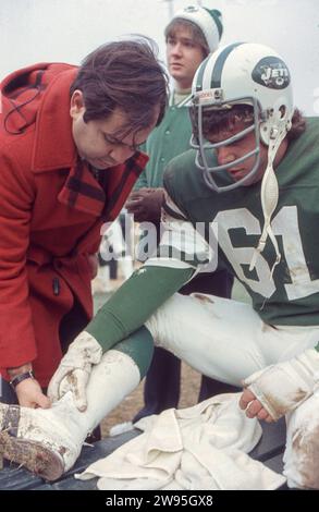 New York Jets ortopedico e medico di squadra Dr. Robert Grossman controlla la salute di un giocatore. Ai margini di una partita di football del 1978 allo Shea Stadium di New York. Grossman faceva parte dello staff dell'Institute of Sports Medicine and Athletic Trauma. L'atleta è John Roman, il lineman dei Jets. Foto Stock