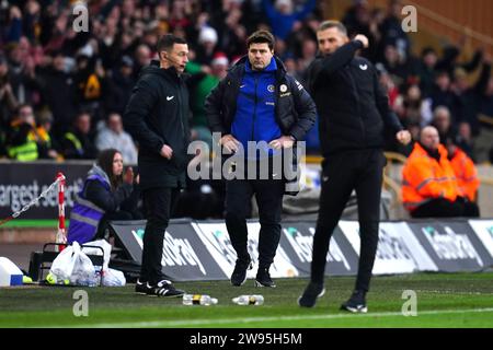 Il manager del Chelsea Mauricio Pochettino (centro) sembra frustrato, mentre il manager dei Wolverhampton Wanderers Gary o'Neil (a destra) festeggia dopo il fischio finale nella partita di Premier League al Molineux Stadium, Wolverhampton. Data immagine: Domenica 24 dicembre 2023. Foto Stock