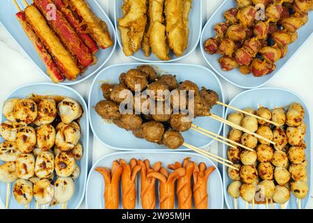 Polpette fritte su spiedini fatte con vari tipi di carne e salsicce, mescolate con farina e condimenti con lattuga come contorni. Molti deliziosi arrosti Foto Stock