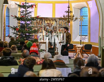 Sieversdorf, Germania. 24 dicembre 2023. I Vespri di Natale con un gioco di presepi si svolgono nella chiesa protestante del villaggio il giorno di Natale. La vigilia di Natale, sono offerti diversi servizi in quasi tutte le chiese protestanti. Nella piccola chiesa del villaggio di Sieversdorf, ogni pomeriggio di Natale si svolgono i Vespri di Natale con un gioco di presepi. Si cantano i famosi canti e si pregano. I bambini e i giovani dei villaggi circostanti eseguono il gioco della natività. Credito: Patrick Pleul/dpa/Alamy Live News Foto Stock