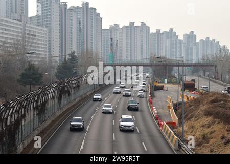 Auto che guidano lungo l'autostrada Olympic-daero circondate da alti edifici residenziali nel quartiere di Songpa Foto Stock