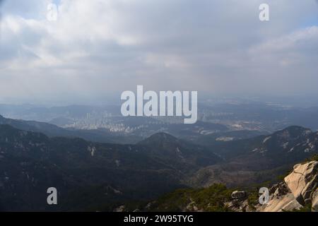 Vista panoramica delle aree urbane di Seoul, vista dalle cime delle montagne sui sentieri escursionistici del Parco Nazionale di Bukhansan Foto Stock