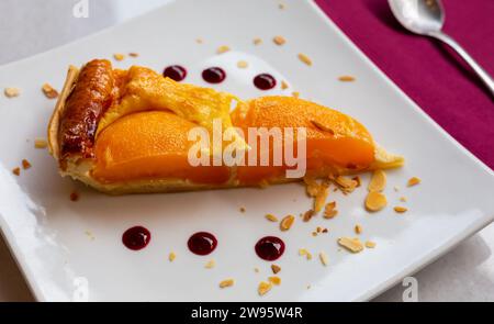 Fetta di crostata di crema alla pesca con mandorle affettate Foto Stock