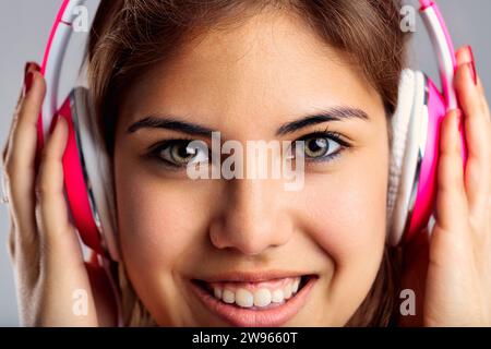 Il ritratto mostra un amante della musica adornato con cuffie alla moda e casual chic Foto Stock