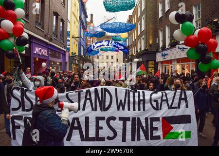 Londra, Regno Unito. 23 dicembre 2023. Manifestanti a Carnaby Street. I manifestanti pro-Palestina hanno marciato attraverso il quartiere dello shopping di Londra prima di Natale, chiedendo un cessate il fuoco. Credito: Vuk Valcic/Alamy Foto Stock