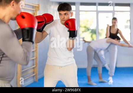 Due pugili in abbigliamento sportivo sono impegnati in pugilato sparring in palestra Foto Stock